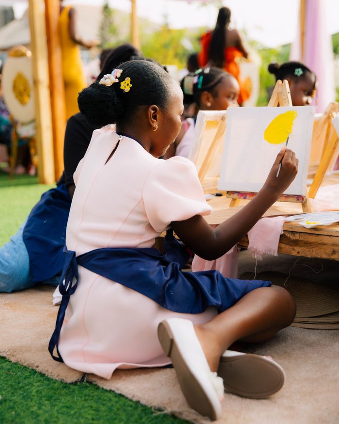Young children enjoy painting in an outdoor art class in a park setting.