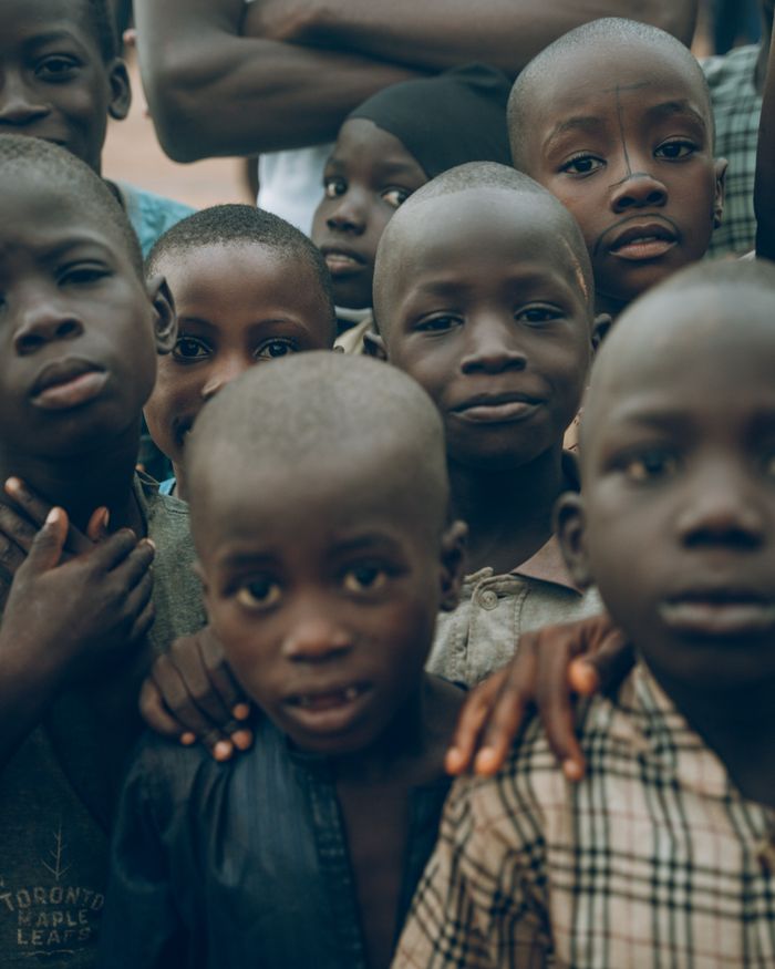 A group of smiling children posing outdoors in Nigeria, showcasing joy and community spirit.